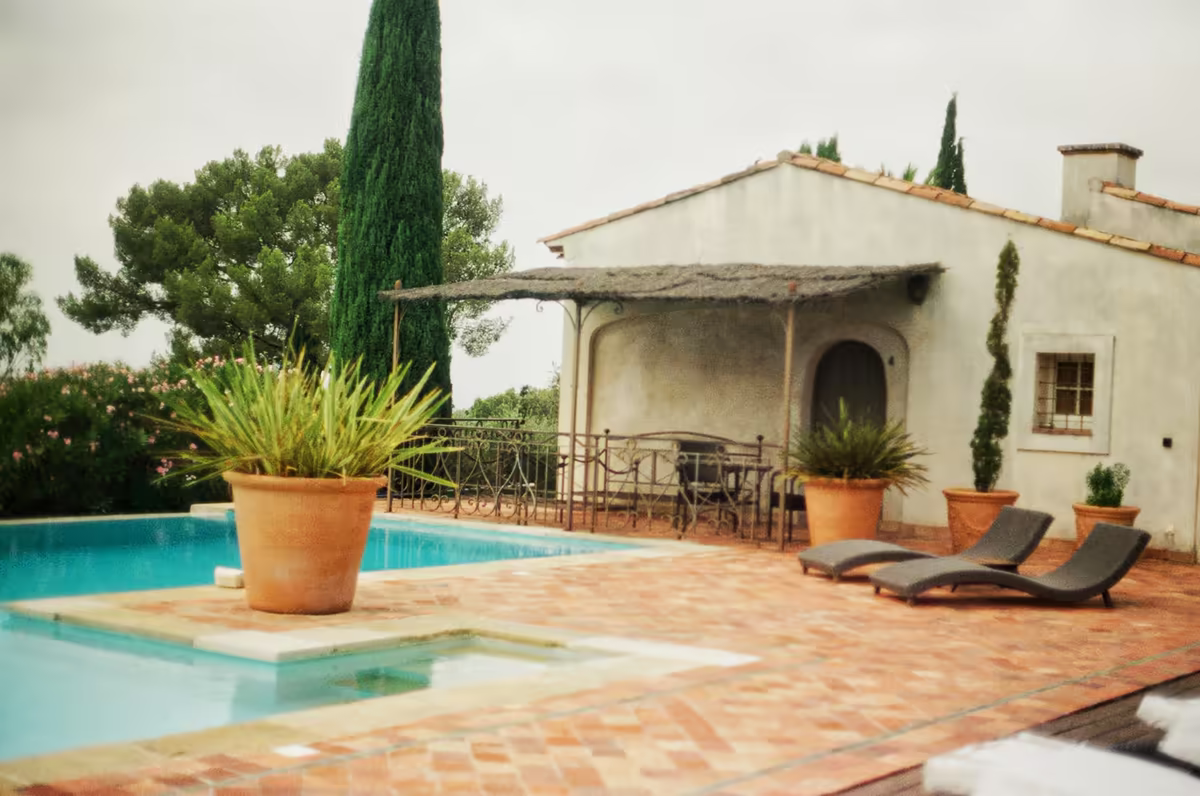 Maison de style provençal avec piscine, terrasse en terre cuite et cyprès